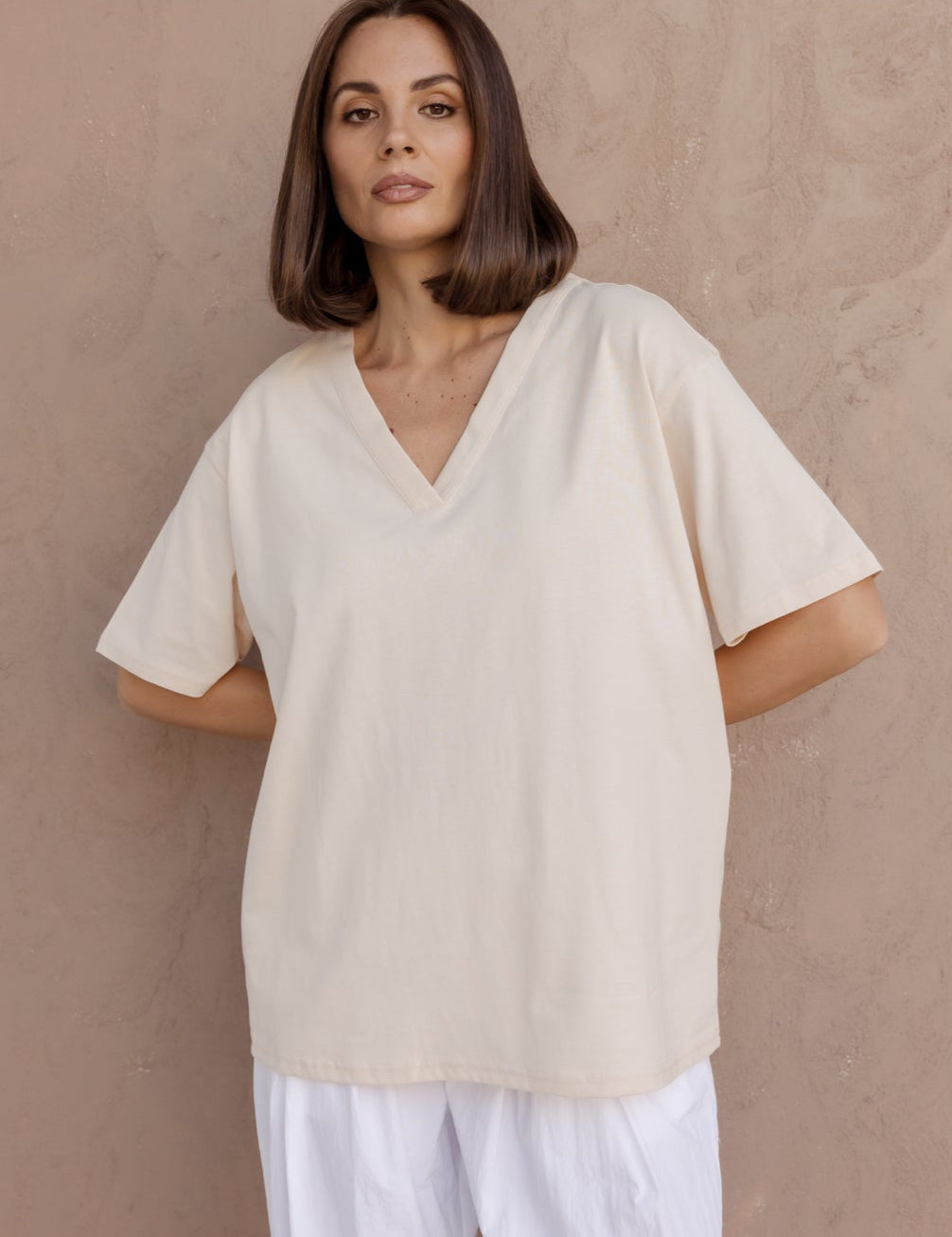 Woman wearing the NIX V-Neck T-Shirt in Cream by ALEXANDRA